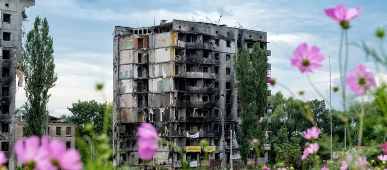 Зруйнований обстрілами багатоповерховий будинок — відбудова України